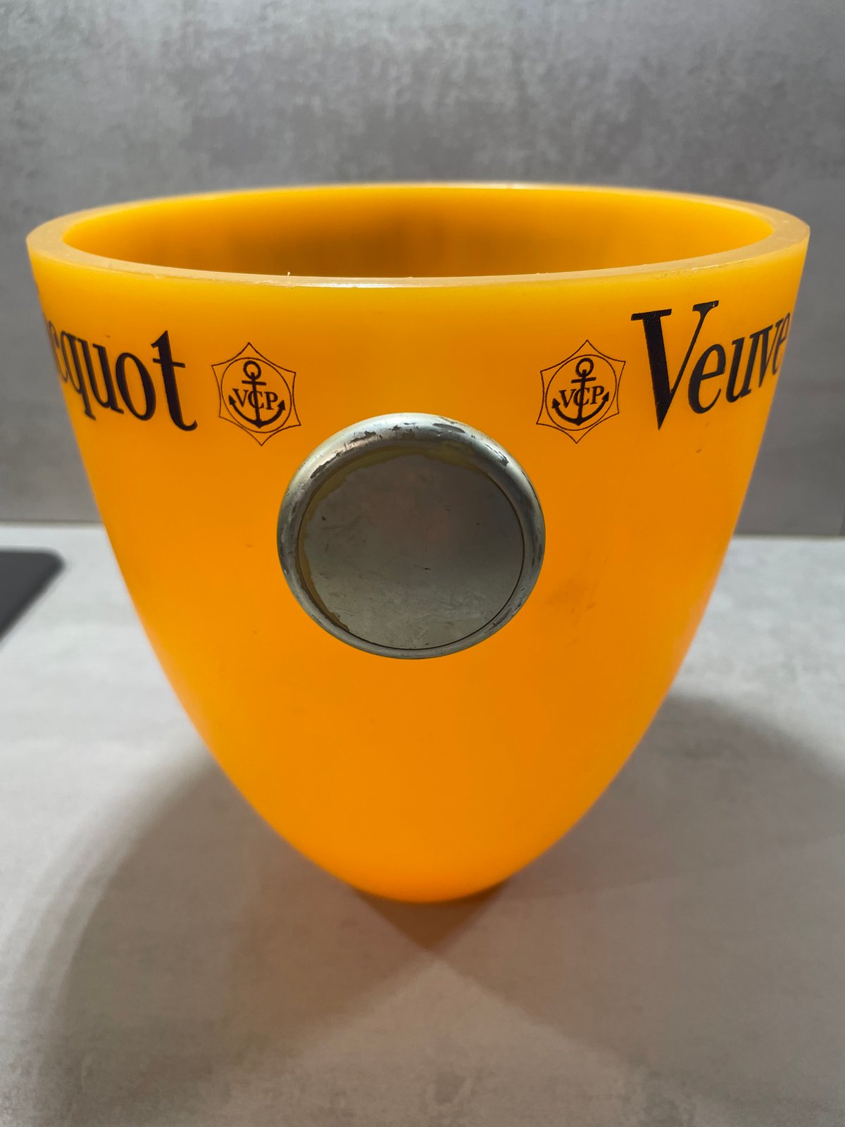 Detail of the translucent orange body and anchor emblem on the Veuve Clicquot champagne bucket