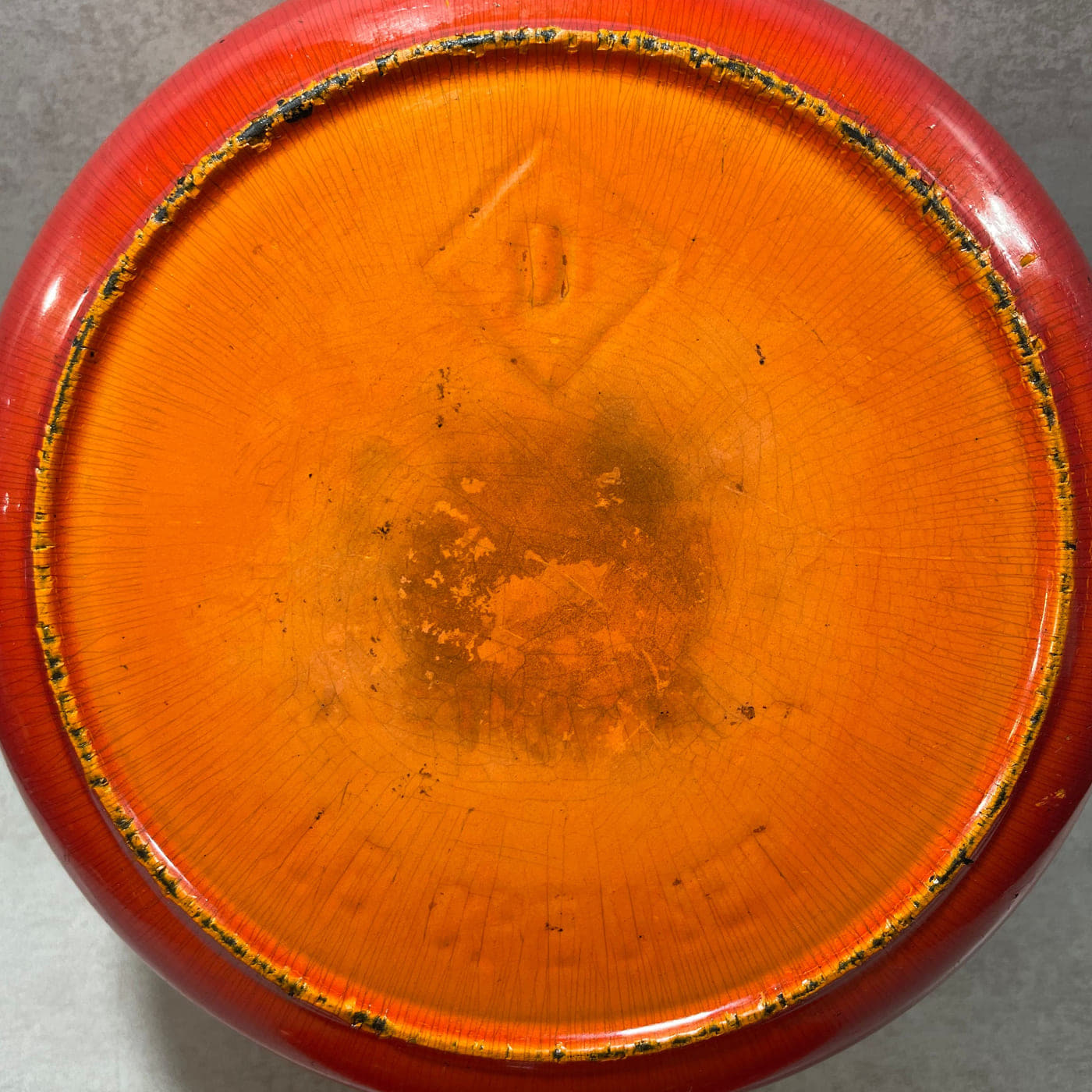 Underside of an early Le Creuset cocotte showing the enamelled base and central marking