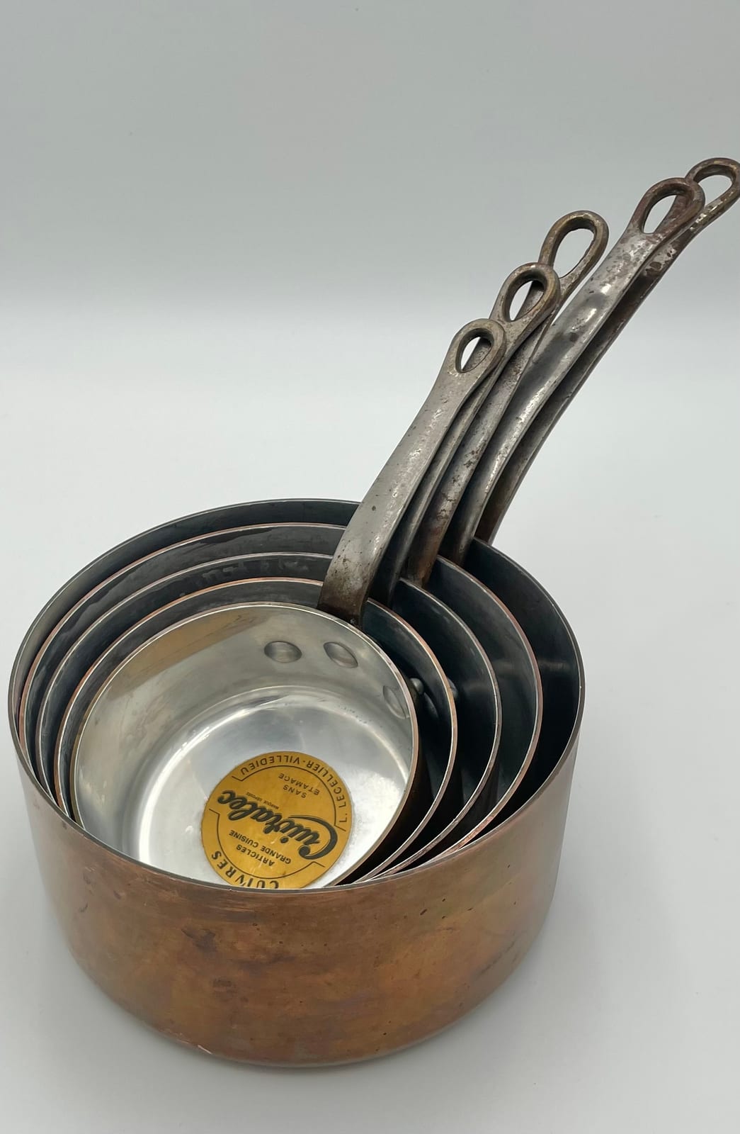 Graduated set of five L. Lecellier Cuivralec copper saucepans nested together, with original paper label visible