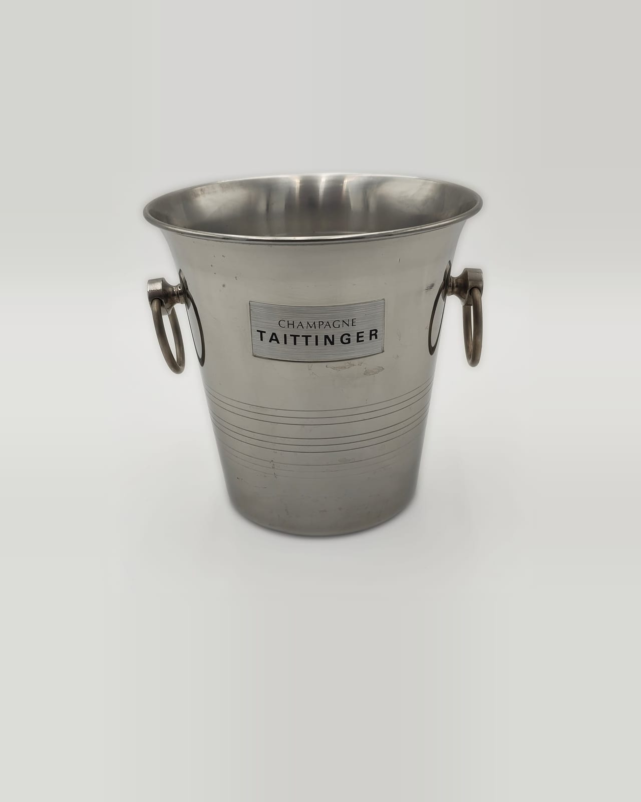 Champagne Taittinger ice bucket by Guy Degrenne in stainless steel, front view with house plaque